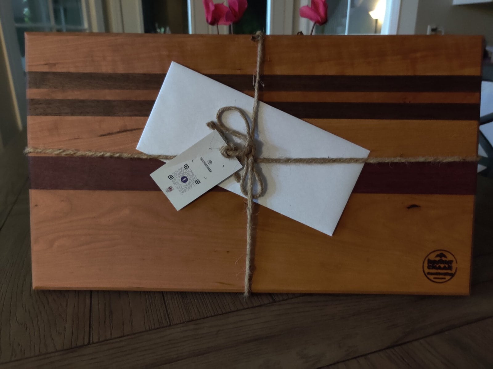 Koshur Chaan Woodworking 7 Striped cutting board tied with twine and a handwritten gift tag