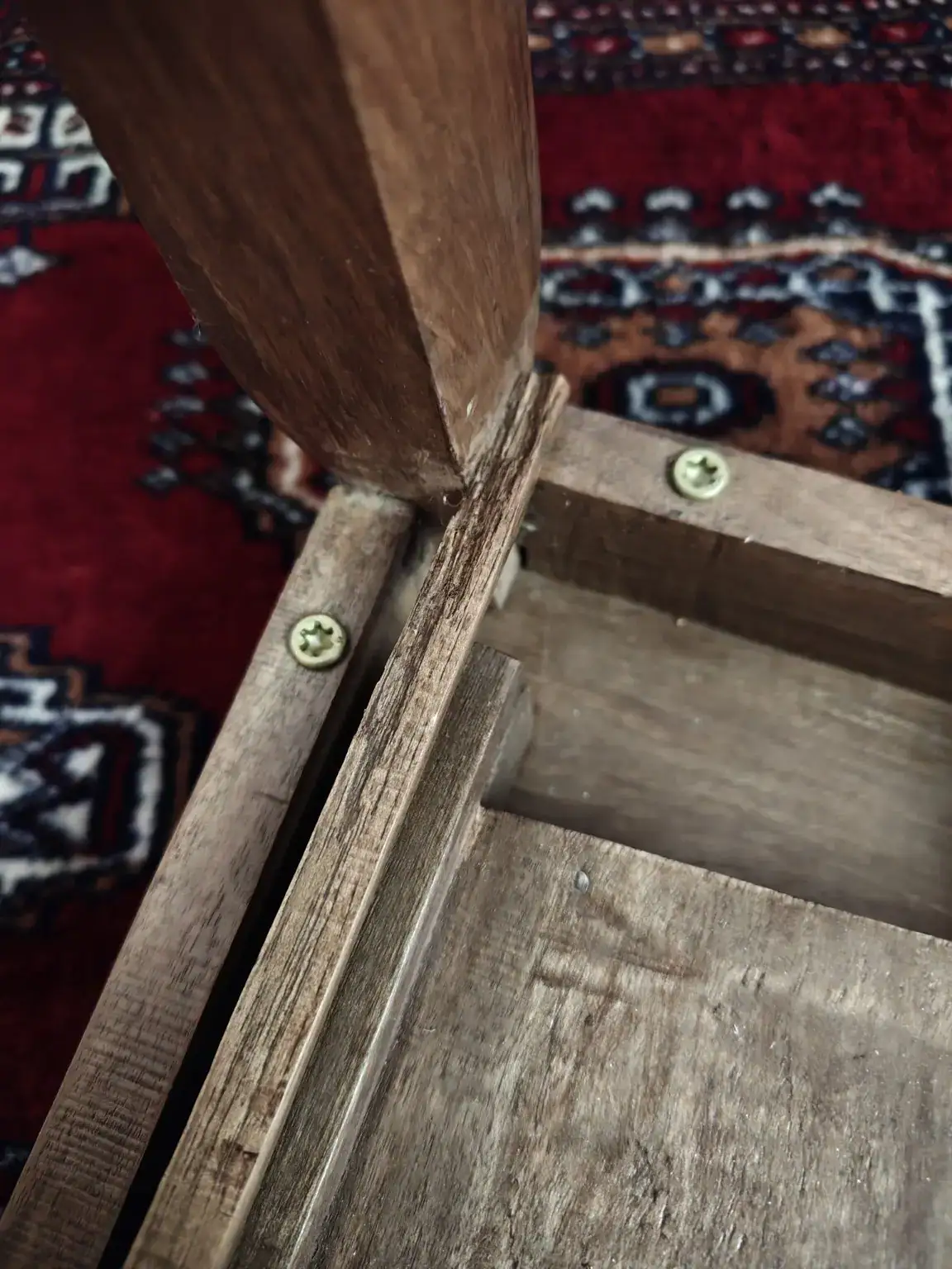 Close-up of split wood and screw placement at a Kashmiri walnut table joint
