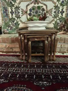 Hand-carved Kashmiri walnut nesting tables displayed in a home
