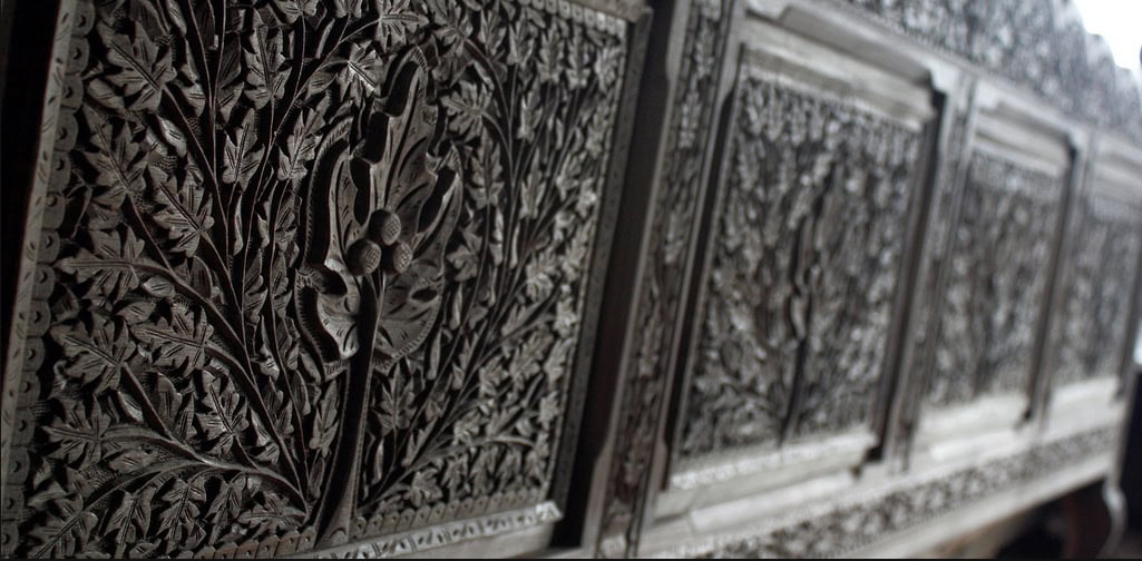Kashmiri craftsmanship up close: close view of intricately carved Kashmiri walnut wood panels with deep floral and geometric relief