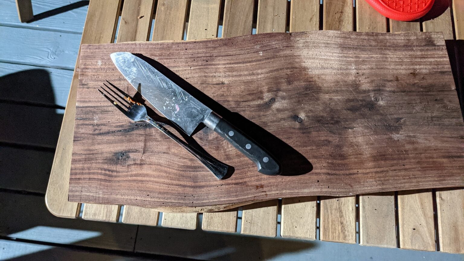 Walnut cutting board with a chef's knife resting on it