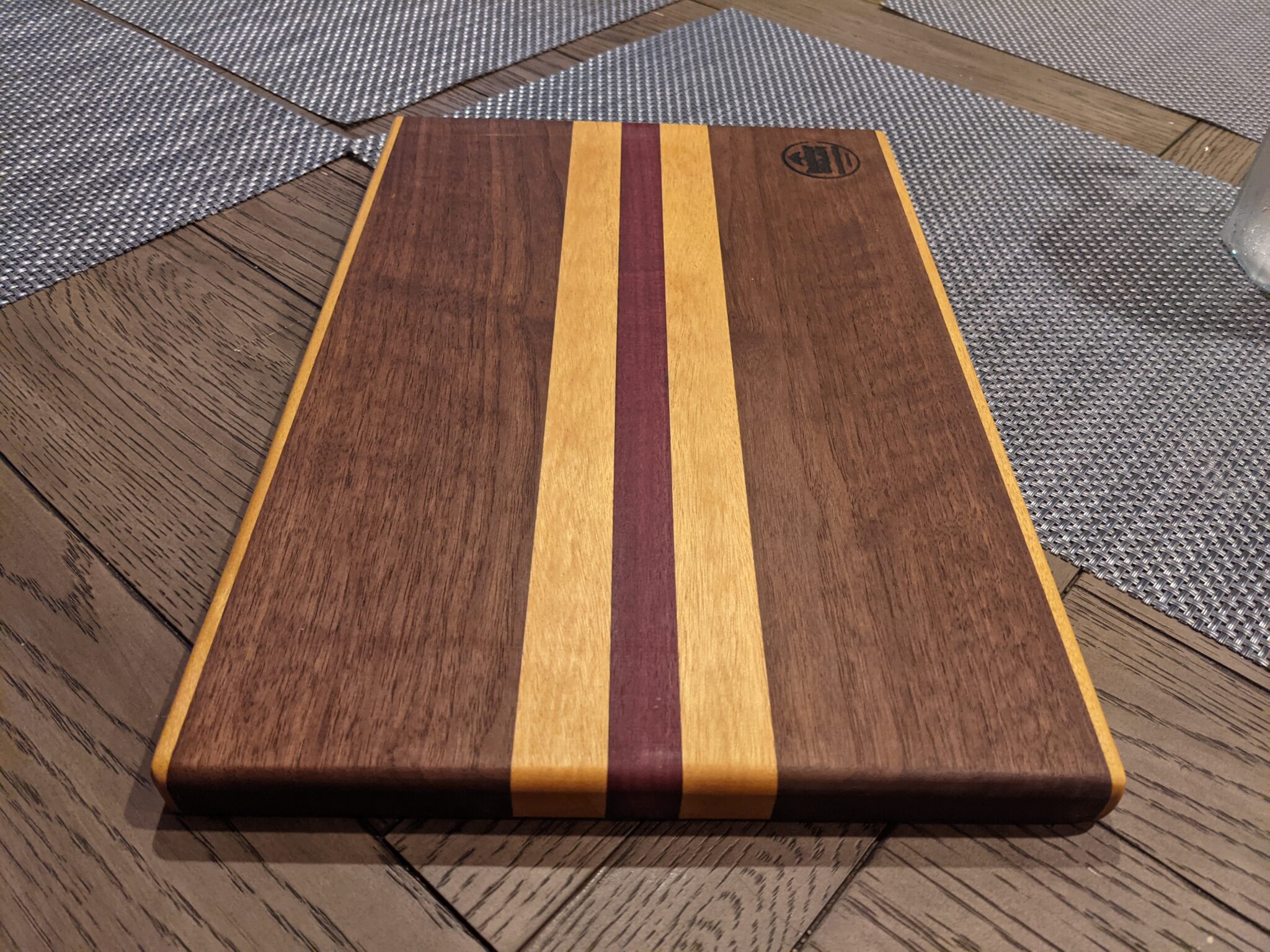 One of our handcrafted cutting boards in Suwanee: walnut cutting board with maple and purple accent stripes down the center