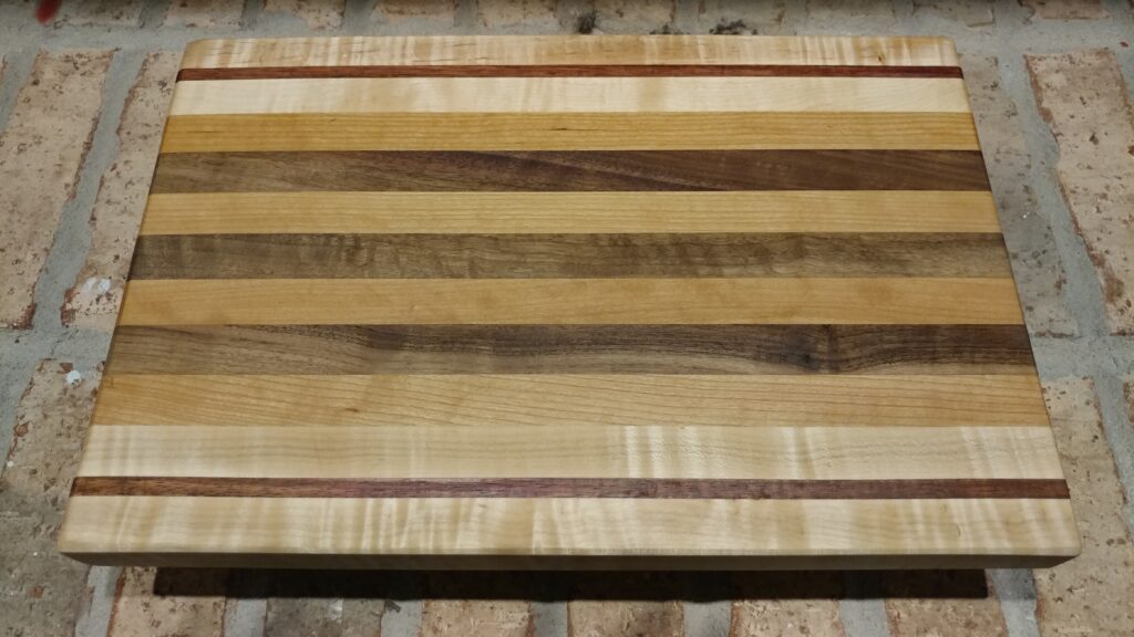 Cutting Board FAQ example: overhead view of a rectangular wooden cutting board with broad brown and pale stripes