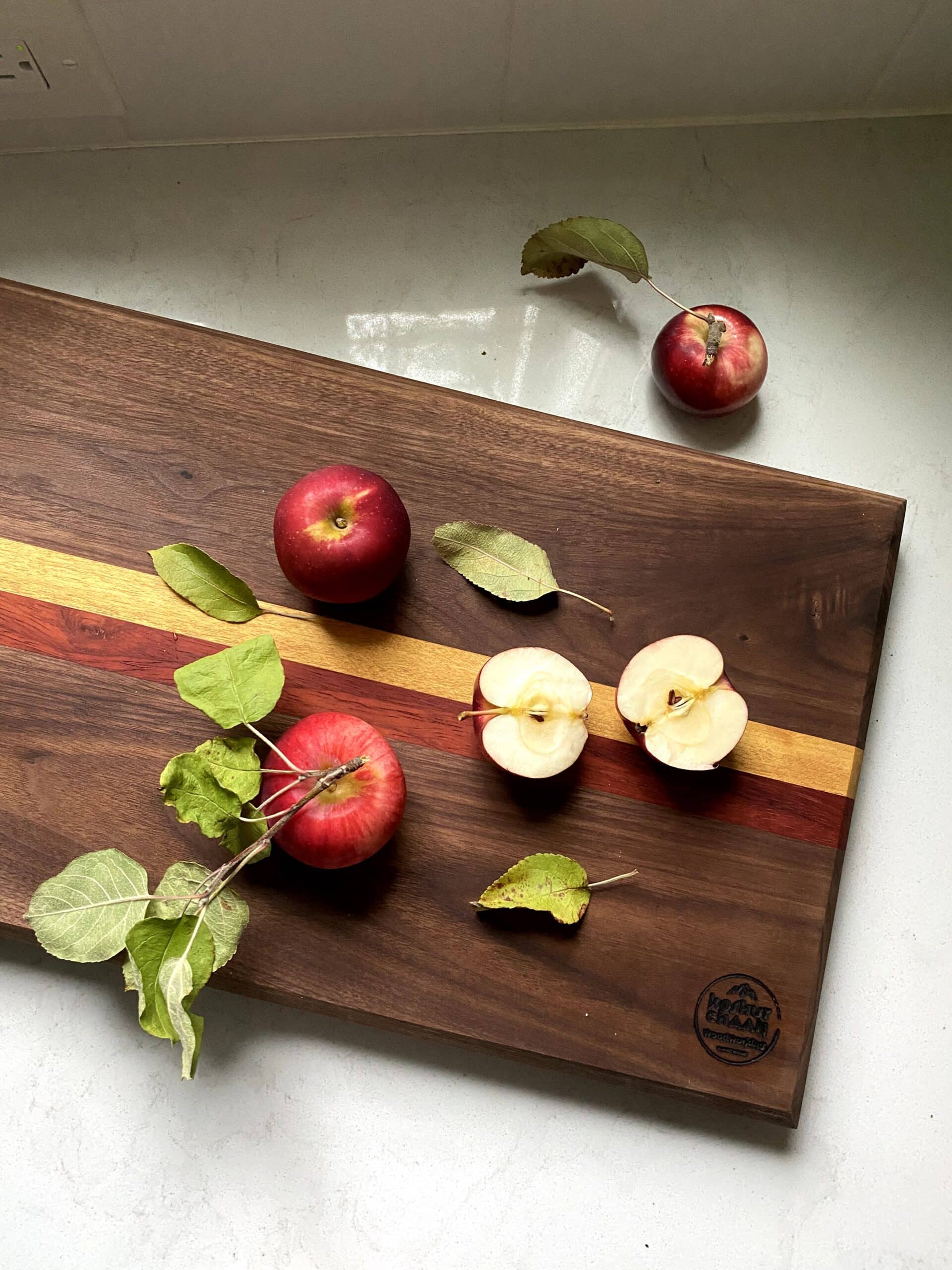 Koshur Chaan Woodworking 1 Koshur Chaan handmade striped hardwood cutting board with apples