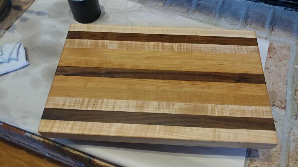 Rectangular striped wooden cutting board resting on a light work surface